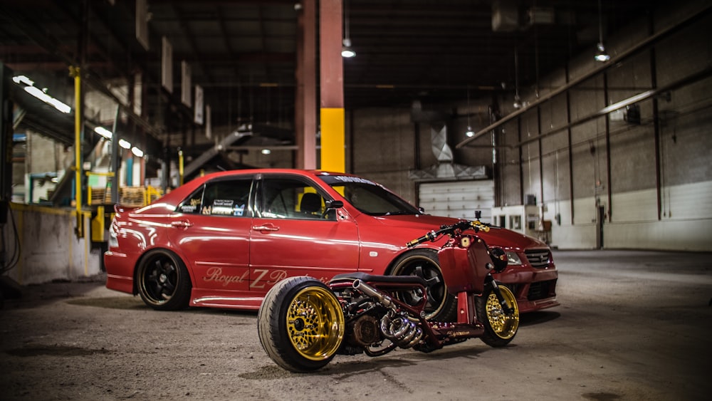 red Mitsubishi Lancer Evolution sedan parking near black motorcycle on garage