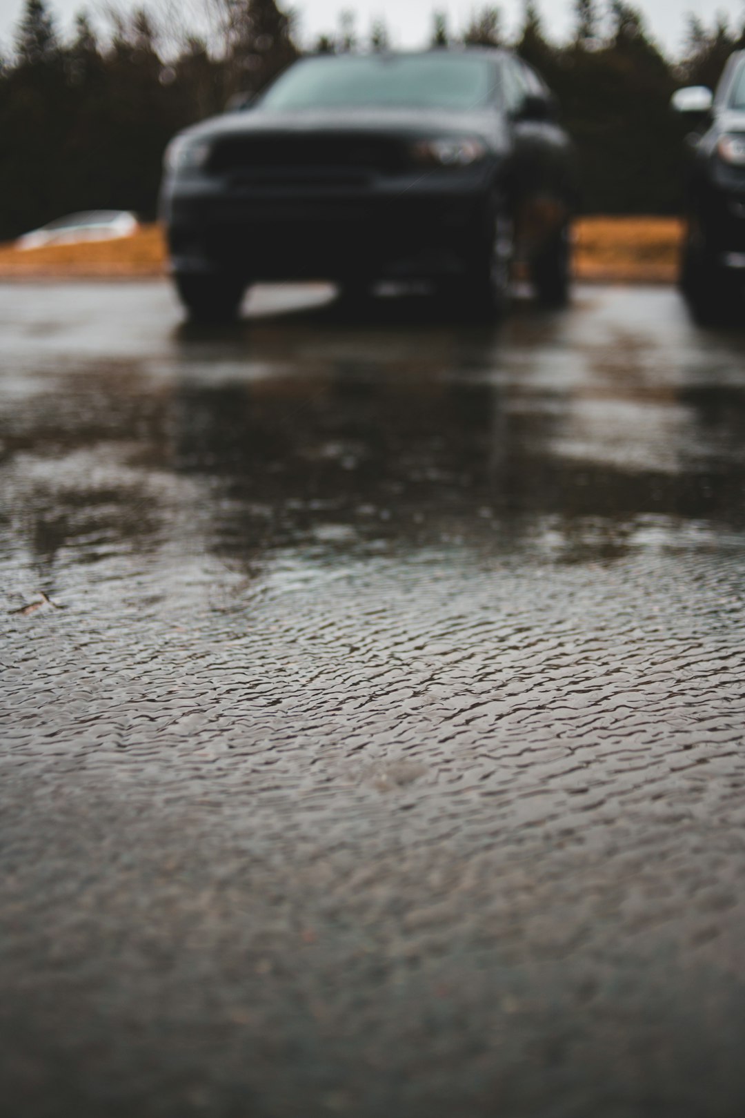 selective focus photo of vehicle parked on concrete pavement