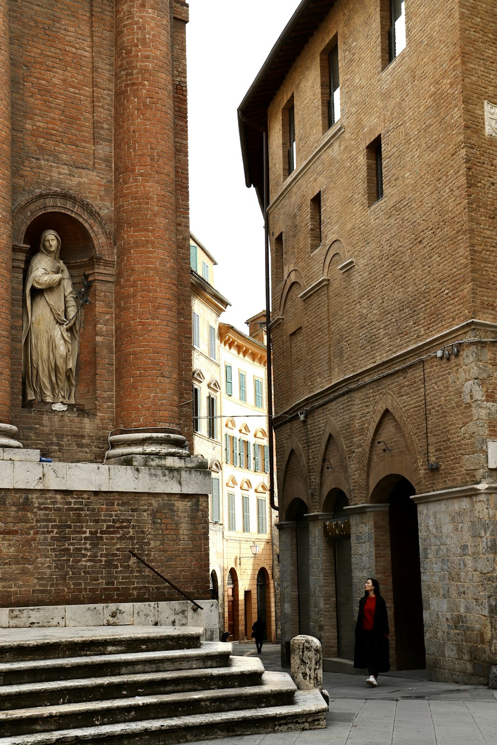 a statue of a woman is on the side of a building