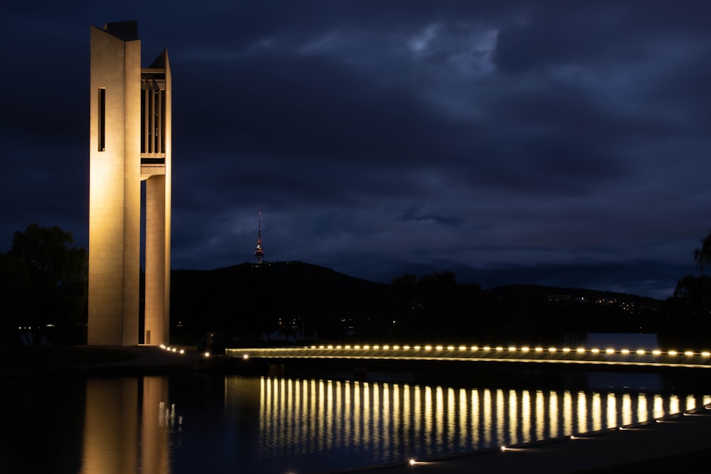 reflection of bridge lights on body of water at night