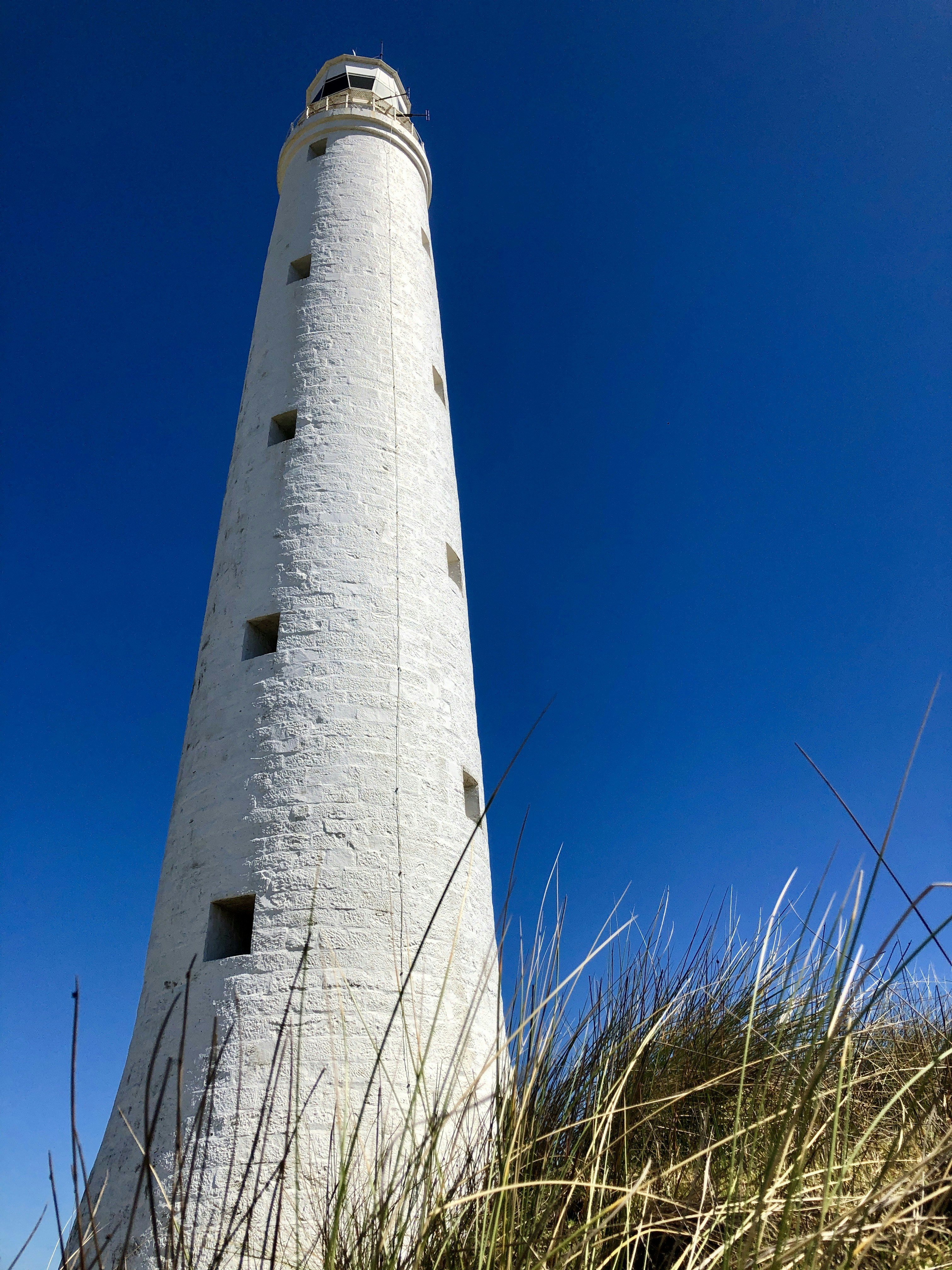 Weißer Betonleuchtturm tagsüber