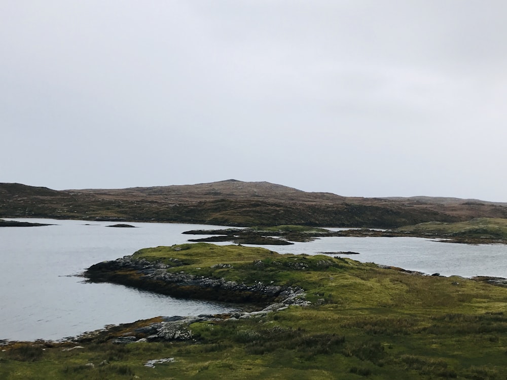 a large body of water surrounded by grass