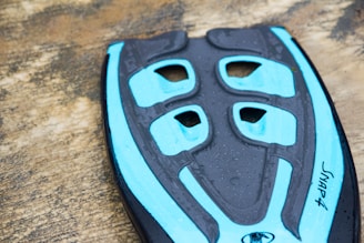 Close-up of a sleek aetherion Zeropoint paddle resting on a dark obsidian surface with electric cyan highlights.