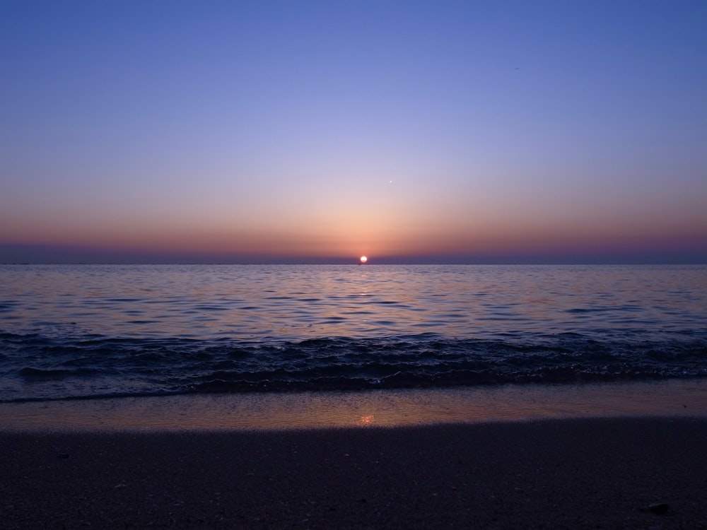 blue body of water during sunrise