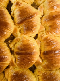 An assortment of buttery croissants arranged neatly on a beige linen cloth.