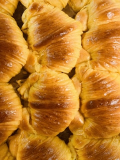 Close-up of golden croissants with flaky layers arranged on a vintage tray.