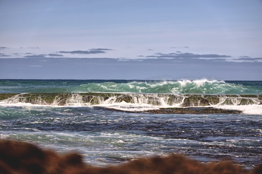 sea wave splashing on concrete barrier