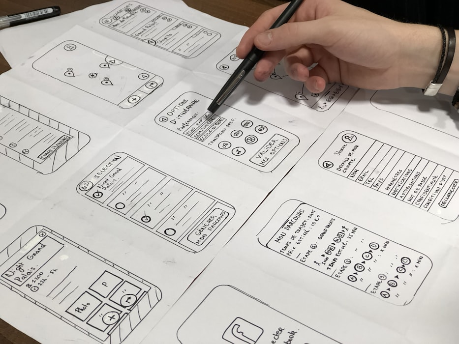 Design team sketching user interface wireframes on whiteboard