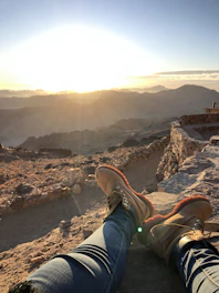 Hiker reaching a scenic viewpoint overlooking Mount Rinjani at sunrise.