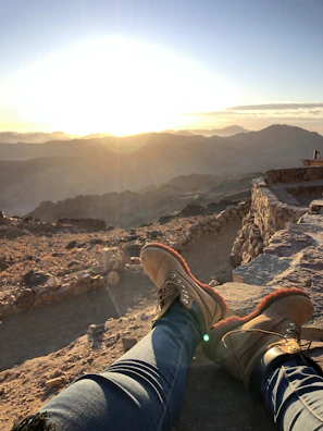 Vibrant photo of a traveler hiking a scenic mountain trail at sunrise.