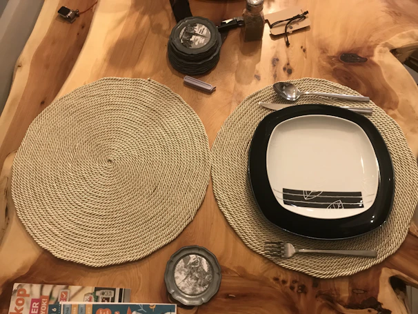 Wooden table adorned with colorful placemats and matching napkins