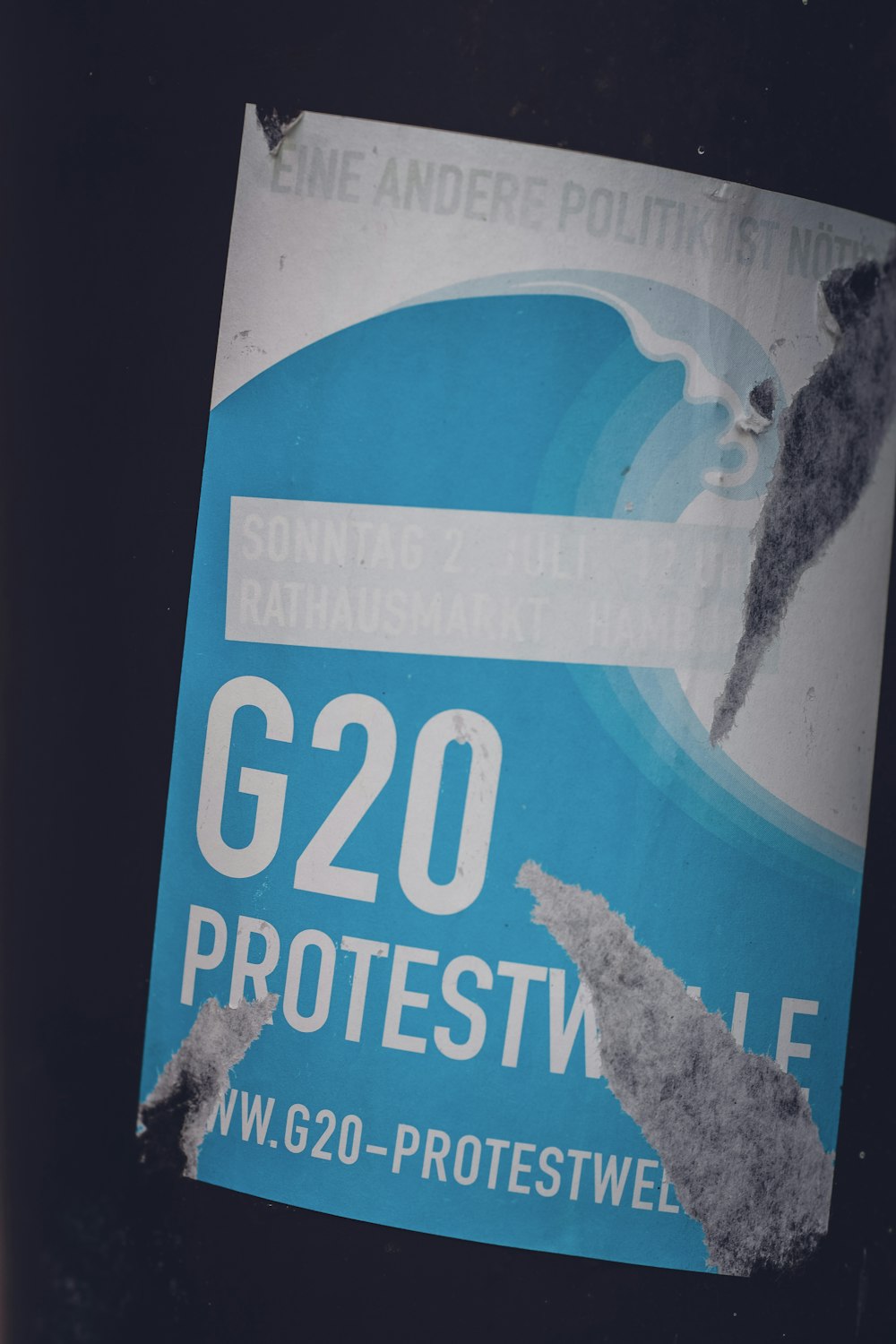 Un autocollant sur un poteau qui dit manifestation du G20