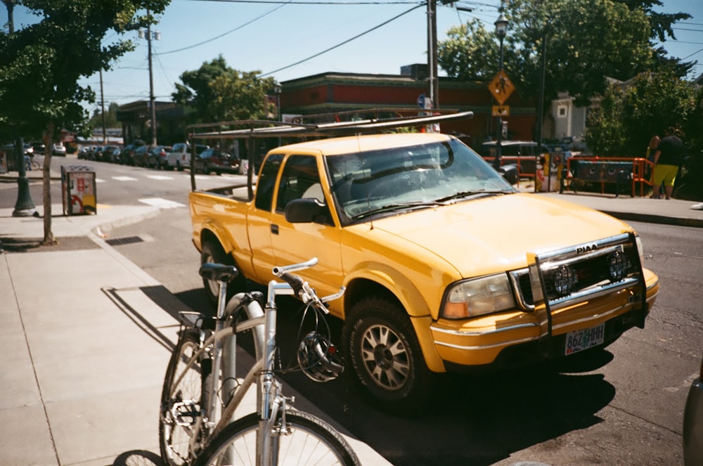 yellow extra cab pickup truck on road near bike parking during daytime