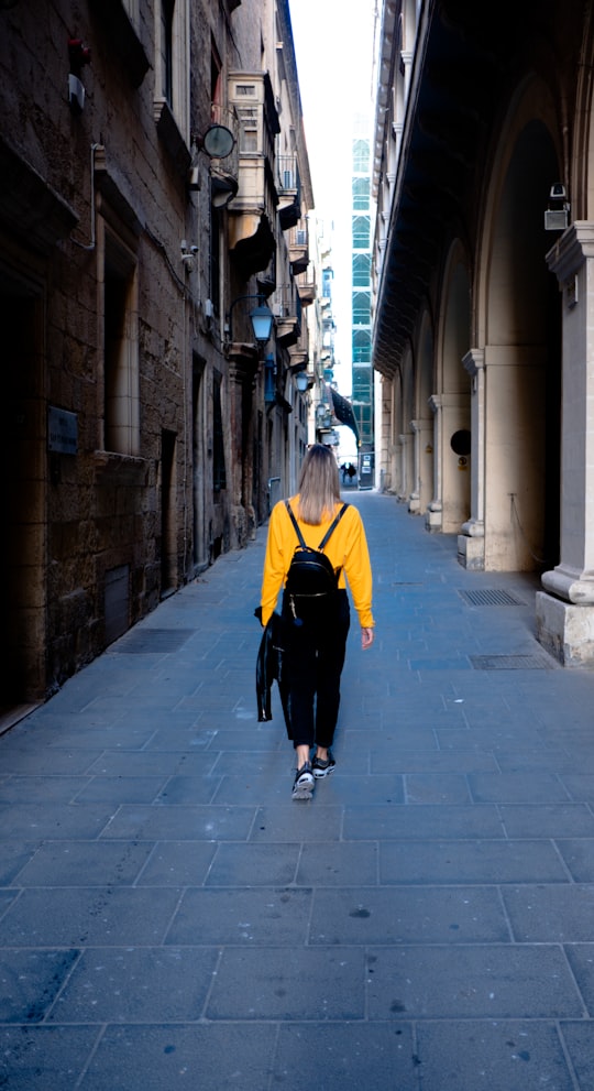 woman walking between buildings during daytime in Valletta Malta