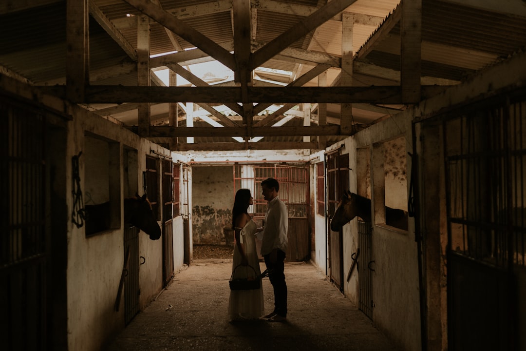 couple standing near horse in barn