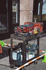 paints on rolling cart near building