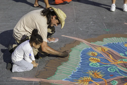 man painting 3D on pavement during daytime