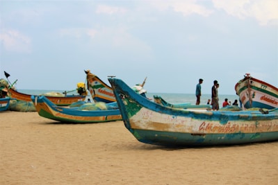 blue-and-white boats on seashore during daytime