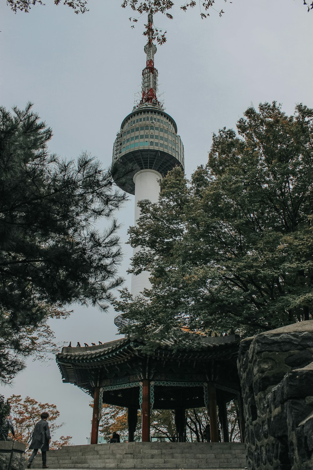 few people near green temple surrounded with green trees during daytime