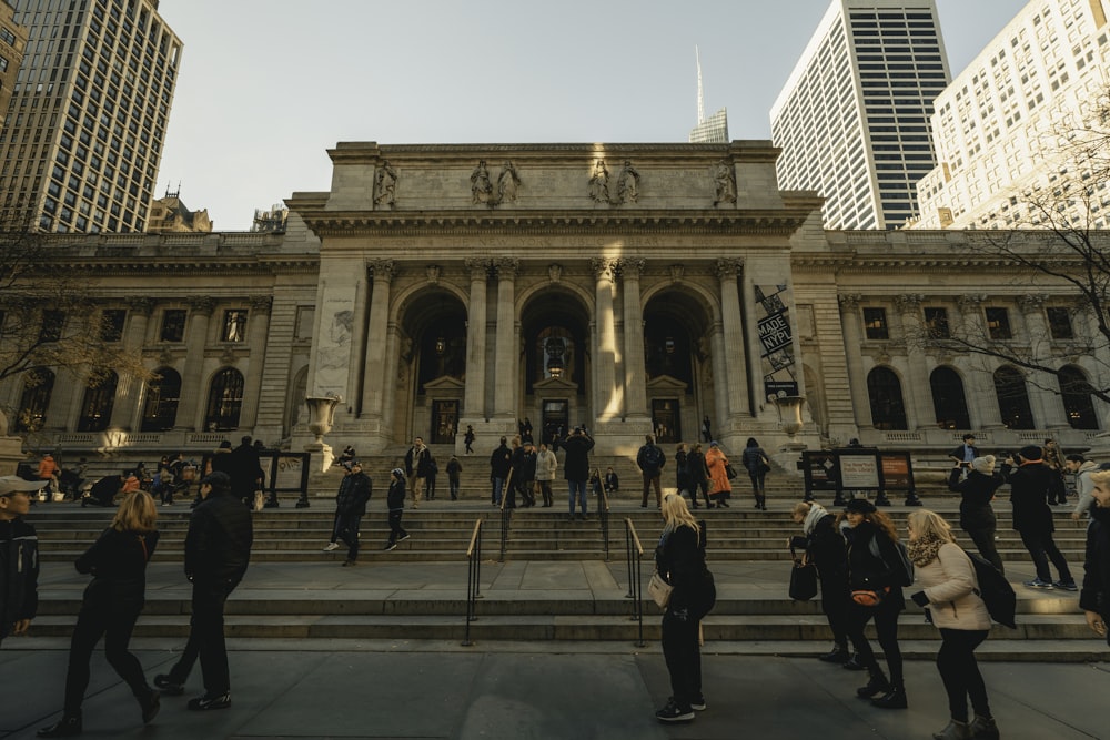 personas caminando cerca de la Biblioteca Pública de Nueva York durante el día