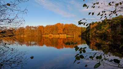 A framed fine art print of a serene lake reflecting autumn colors.
