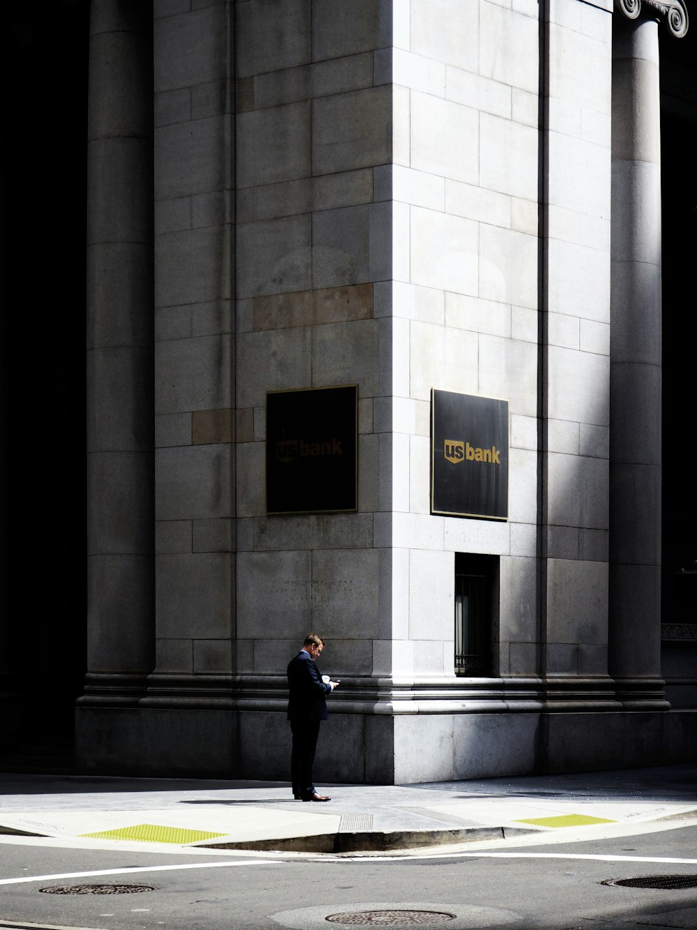 man standing near road beside building during daytime