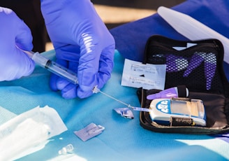 person using disposable syringe put specimen on blue and white glucose meter