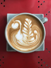 Detailed swan pattern latte art on creamy coffee.