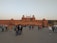 A group of happy tourists exploring a vibrant Rajasthan fort under clear blue skies.