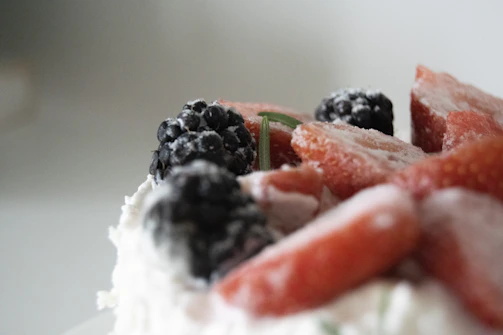 Close-up of a creamy keto dessert topped with fresh berries and mint leaves.