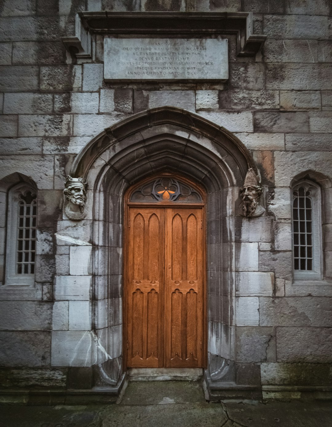 photo of brown wooden door panel and gray concrete building