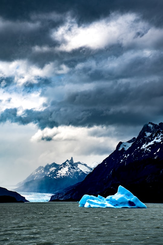 iceberg viewing mountain covered with snow under white and gray sky in Torres del Paine Chile