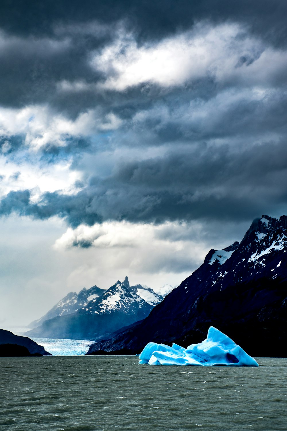 iceberg viewing mountain covered with snow under white and gray sky