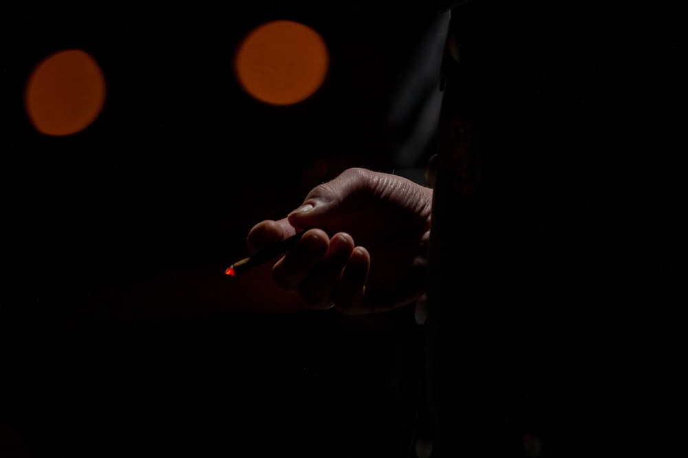 person holding lighted single cigarette
