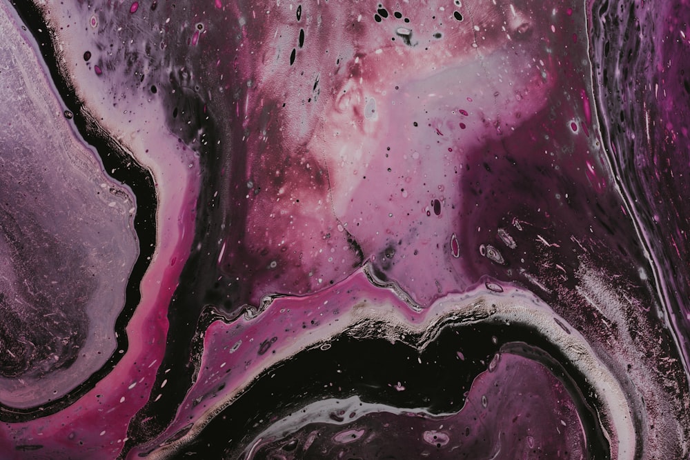 a close up of a purple and black abstract painting