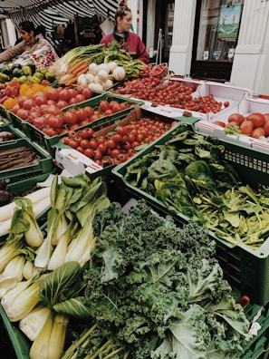 different vegetables on display and women standing near vegetable
