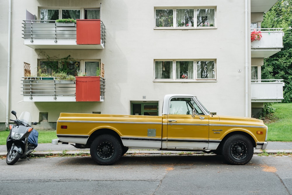 parked pickup truck and motorcycle beside concrete building at daytime