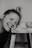grayscale photo of woman smiling and leaning towards stool