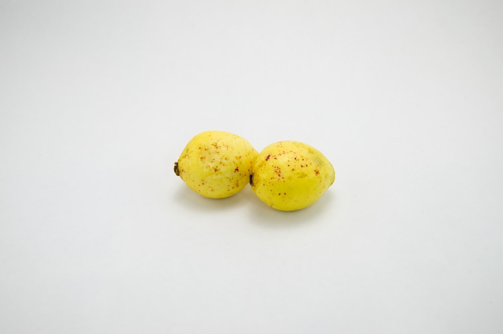 yellow lemons on white surface
