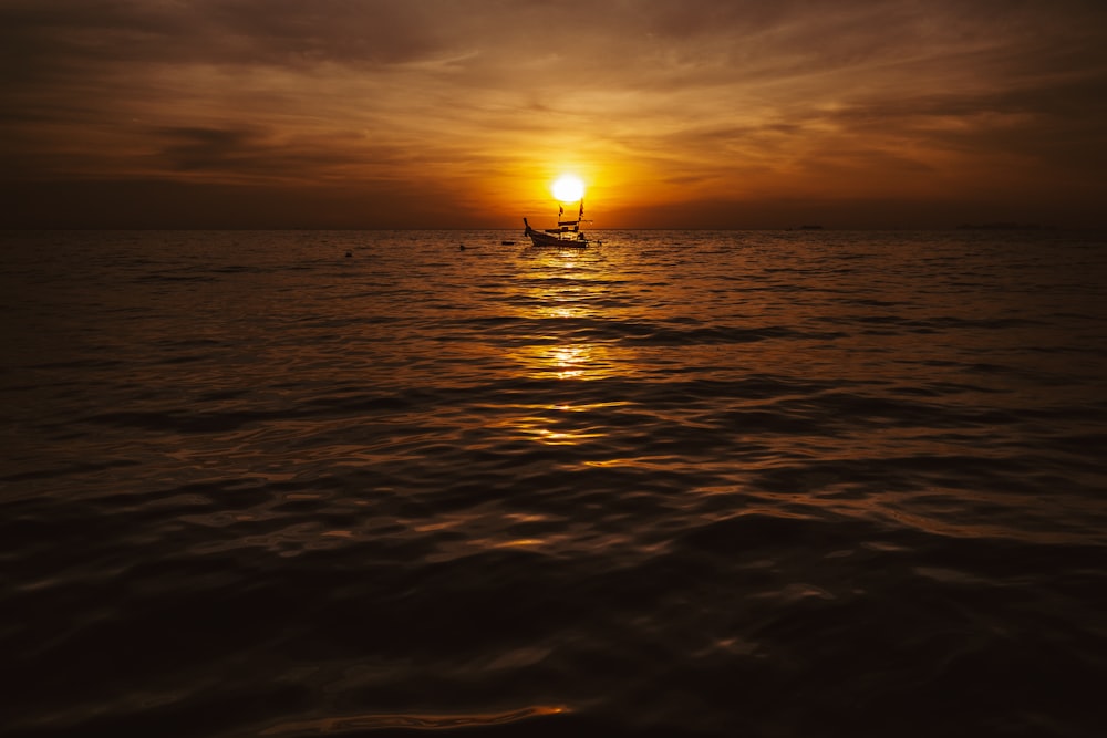 boats under cloudy sky during golden hour ]