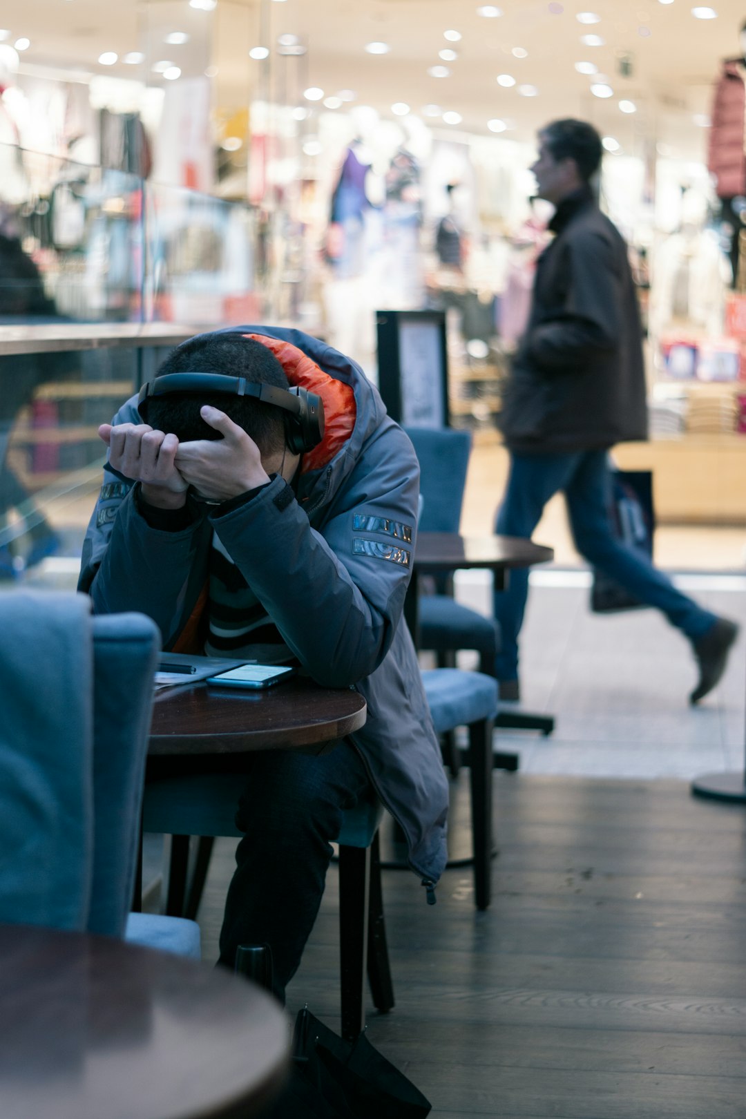 man sitting beside table with turned on smartphone