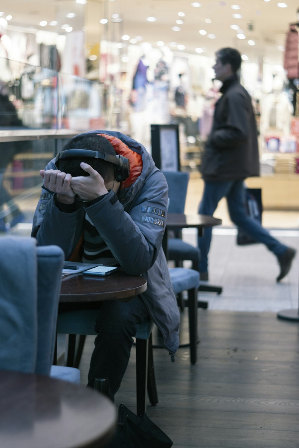 Mann sitzt neben Tisch mit eingeschaltetem Smartphone