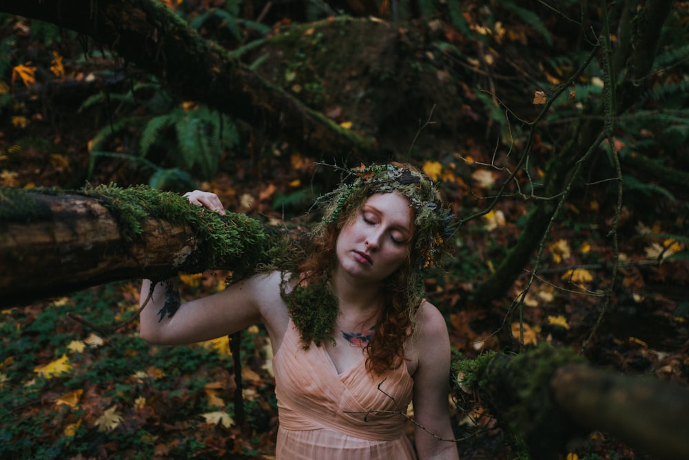 woman in orange dress holding branch with moss