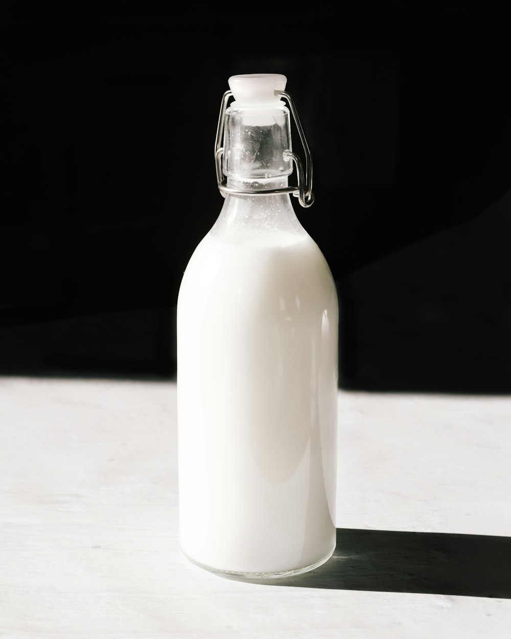 Bouteille en verre transparent remplie d’un liquide blanc