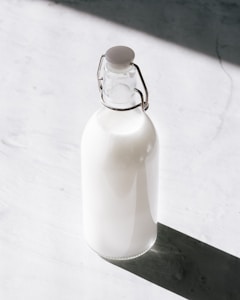 clear glass bottle filled with milk