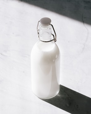 clear glass bottle filled with milk