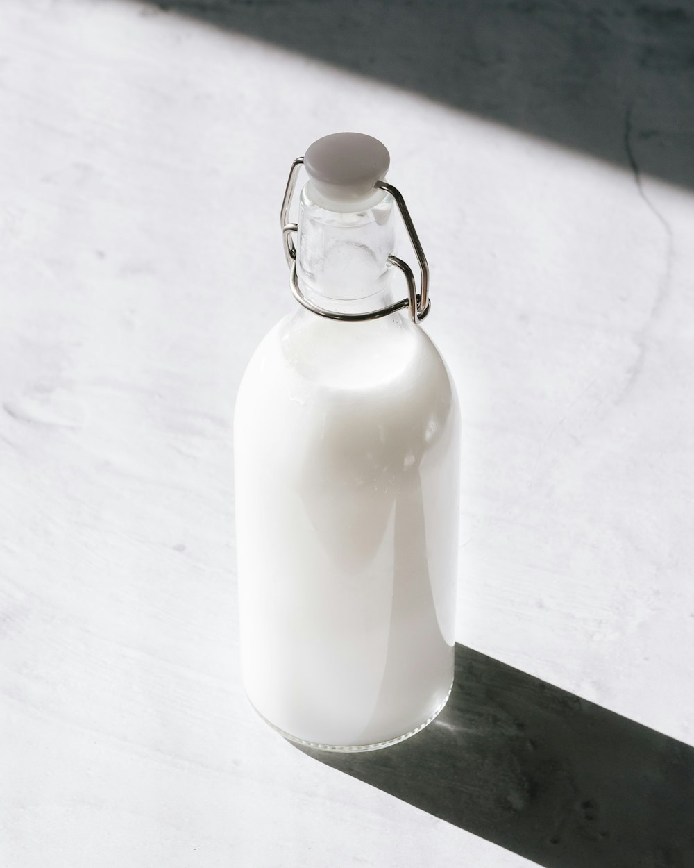 Klarglasflasche gefüllt mit weißer Flüssigkeit