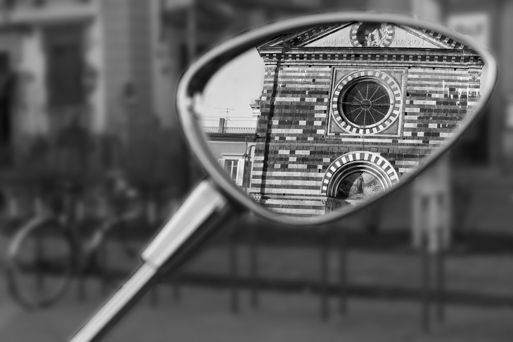 grayscale photography of historic building reflecting on side mirror