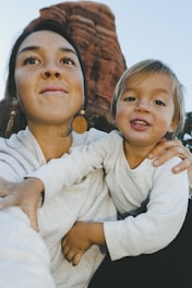 A candid portrait session with a mother and child in natural light outdoors.