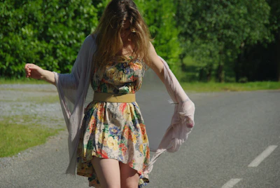 A cheerful person in a flowing summer dress walking through a sunlit park, capturing movement and light.